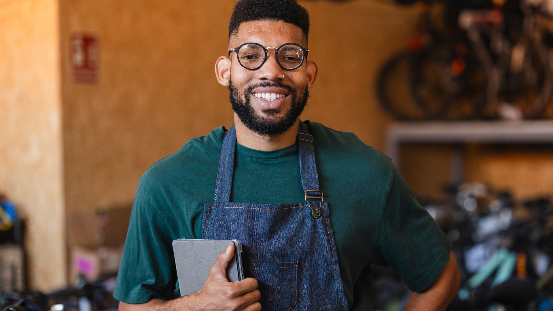 Small business owner at a bike shop holding a tablet